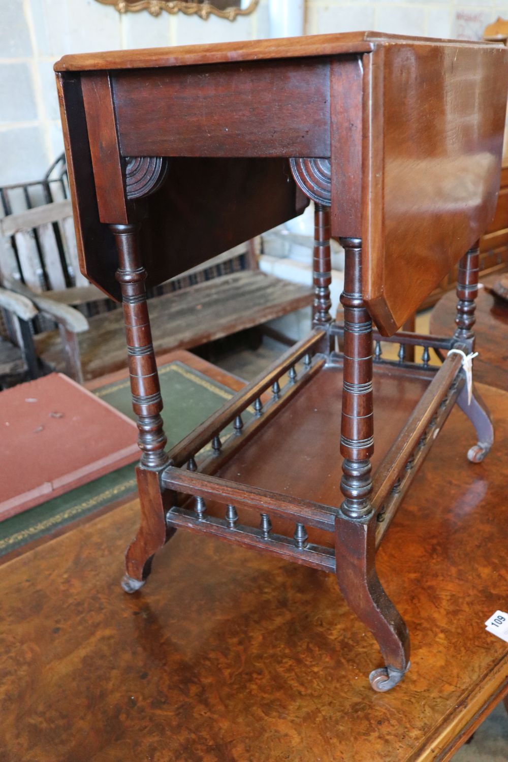 A Victorian Aesthetic period mahogany occasional table, with canted flaps and galleried understage, width 61cm